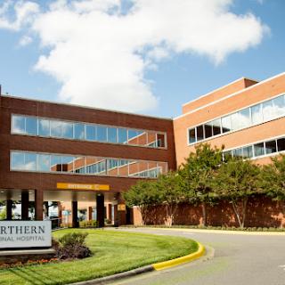 A modern healthcare facility under a partly cloudy sky.