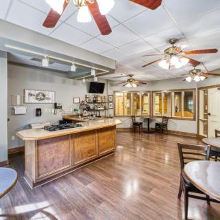 A well-lit office reception area with wooden flooring, featuring a counter and seating space.