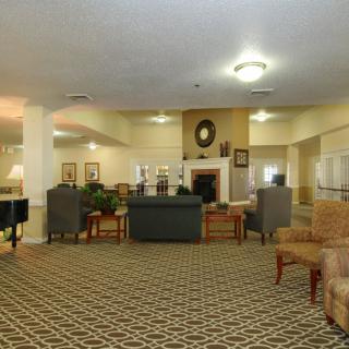 A spacious lobby with comfortable seating and a central fireplace.