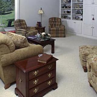 A cozy living room featuring a sofa, armchairs, coffee table, and built-in bookshelves.