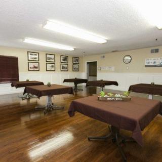 A classroom setting with tables covered in brown cloths, arranged on a wooden floor.