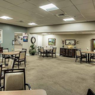 A spacious dining area with neatly arranged tables and chairs, featuring calming decor and ambient lighting.