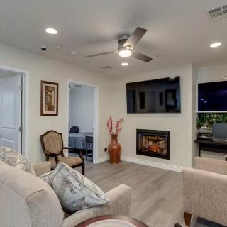 A modern living room featuring a cozy seating area, wall-mounted television, and an elegant fireplace.