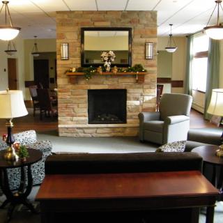 A cozy living room with a stone fireplace, comfortable seating, and elegant decor.