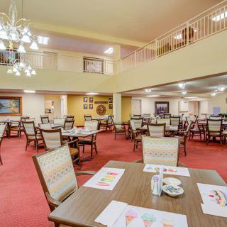 A spacious dining room with neatly arranged tables and chairs, featuring a warm and inviting decor.