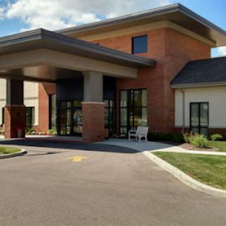 A modern commercial building with a welcoming entrance and landscaped surroundings.