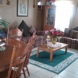 A cozy living room with a sofa, dining table, and coffee table adorned with decorative items.