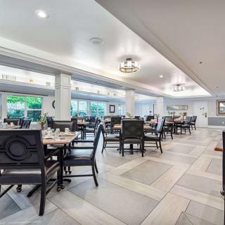 A modern, elegant dining area with neatly arranged tables and chairs inside a restaurant.