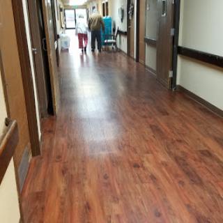 A view of a hospital corridor with people walking in the distance.