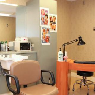 A beauty salon interior featuring a hairdressing area and a nail station.
