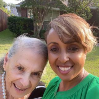 Two women smiling for a selfie in a garden.