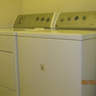 A washing machine and dryer set in a laundry room.