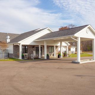 A small clinic building with a covered entrance and parking area.