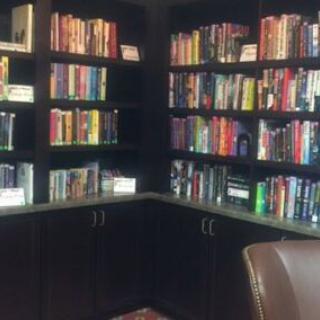 A cozy corner filled with books on dark wooden shelves.
