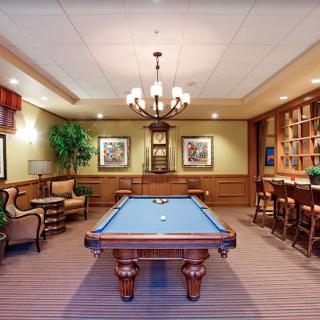 A stylish game room featuring a pool table and elegant wooden decor.