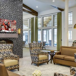 A stylish living room with patterned chairs, a sofa, and a wall-mounted television.