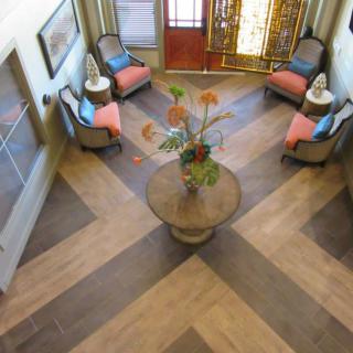 A stylish entryway featuring a central table with decorative plants, surrounded by chairs.