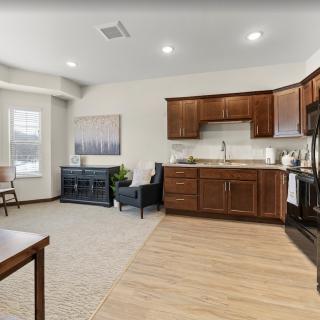 A modern open-concept kitchen and living area with wood cabinets and contemporary furnishings.