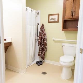 A clean bathroom with a shower, toilet, and sink.