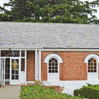 A brick house with arched windows and a glass entryway.