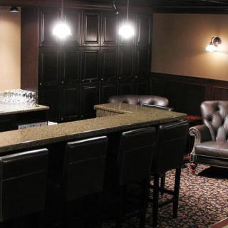 A cozy bar area with leather seating and warm lighting.