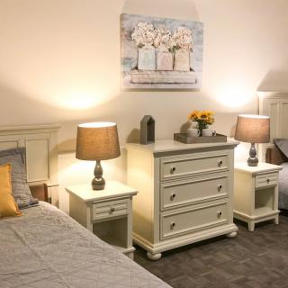 A cozy bedroom with matching furniture and warm lighting.
