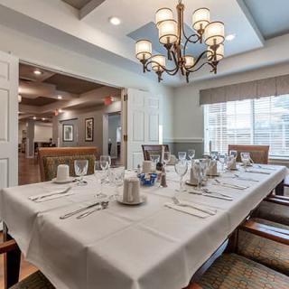 A well-appointed dining room with a formal table setting and chandelier.