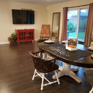 A cozy living space with a television, dining table, and puzzle in progress.