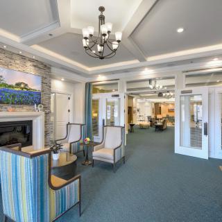A modern lobby interior featuring a chandelier, seating area, and a fireplace with stylish decor.