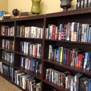 A well-organized bookshelf filled with a variety of books in a home library setting.