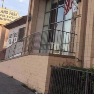 An urban building with a ramp, American flag, and visible signage.