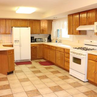 Spacious kitchen with wooden cabinets and modern appliances.