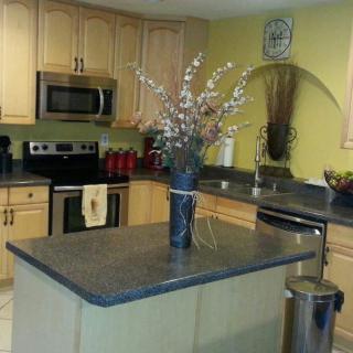 A modern kitchen with a central island and decorative vase.