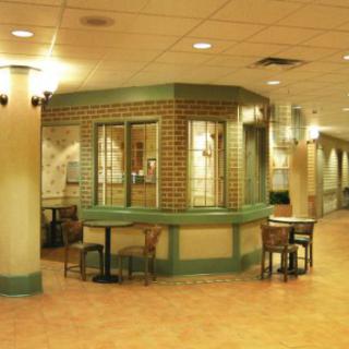 A well-lit lobby interior featuring a central reception desk and seating area.