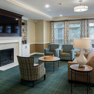 A cozy living room with comfortable seating, a fireplace, and a wall-mounted TV.