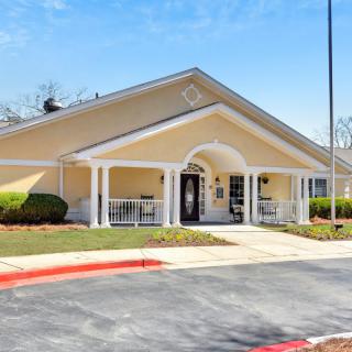 A single-story residential building with a front porch and driveway.