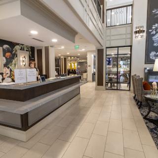 A spacious and modern hotel lobby featuring a reception desk and stylish seating arrangements.