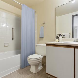 A modern bathroom with a shower, toilet, and sink.
