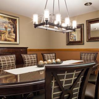 A beautifully designed dining room featuring a large table, elegant chairs, and stylish lighting.