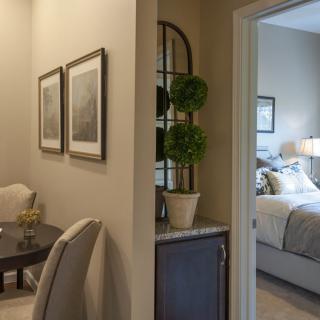 A cozy interior view showing a transition from a living area to a bedroom, featuring elegant furniture and decor.