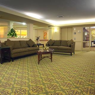 A spacious lobby with comfortable sofas and a patterned carpet.