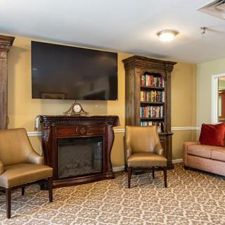 A cozy living room with a fireplace, television, bookshelves, and comfortable seating.