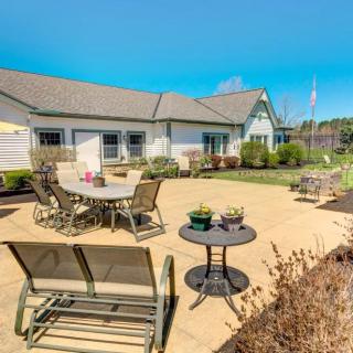 A sunny backyard patio with various outdoor furniture and well-maintained landscaping.