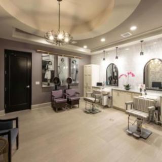 A modern salon interior with styling chairs and mirrors, featuring elegant lighting.