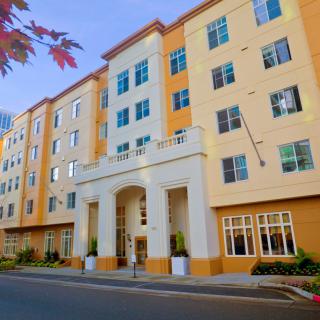 A multi-story residential apartment building with a symmetrical facade and large windows.