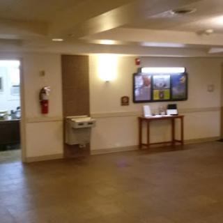 A view of a lobby area featuring a water fountain and informational displays.