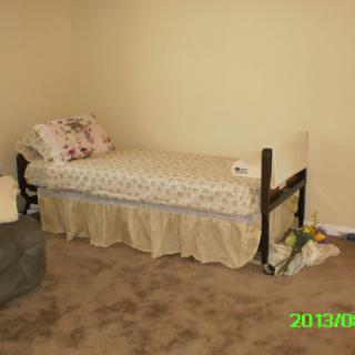 A simple bedroom with a single bed and minimal decor.