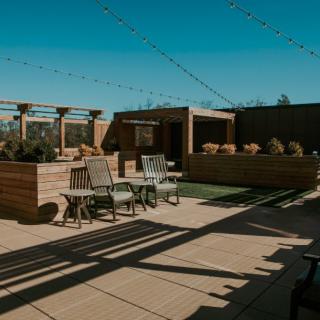 A stylish rooftop patio featuring comfortable seating and ambient string lighting.