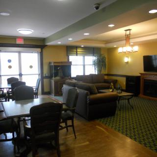 A cozy lobby area with sofas, a television, and seating arrangements.