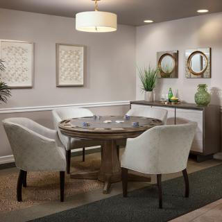 A cozy dining space featuring a round table surrounded by upholstered chairs, complemented by minimalist decor and wall art.